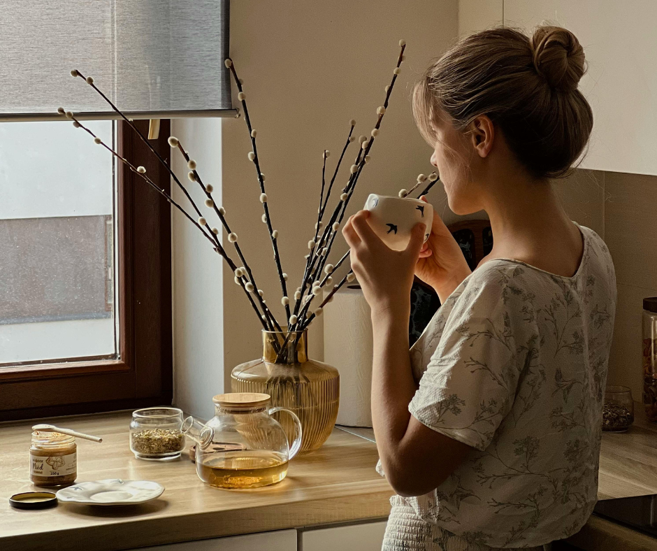 woman drinking green tea in beige kitchen 